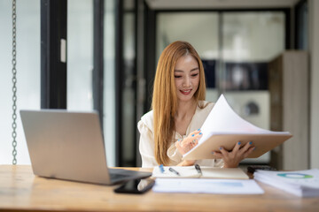 Business woman sitting and working using laptop, searching and checking information