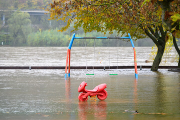 Swing set and bouncy toy on a flooded playground