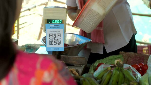 Vegetable seller measuring the quantity of fresh tomatoes - fresh vegetables  weighing scale  business transaction. A shot of a vendor selling vegetables to a woman in a street market - green veget...