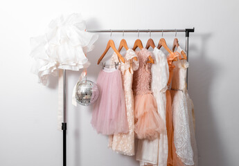 Dresses on hangers in white wardrobe.