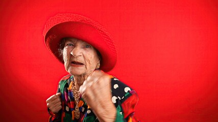 Funny portrait of elderly mature angry aggressive woman trying to fight towards camera, shaking...