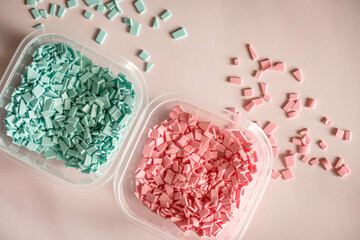 A pile of plastics - small pieces of hard plastic, pink and blue color, intended for further processing