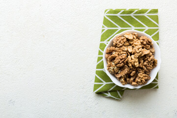 Fresh healthy walnuts in bowl on colored table background. Top view Healthy eating bertholletia concept. Super foods