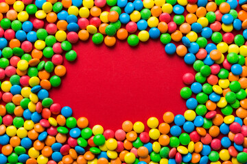 Mixed collection of colorful candy, on colored background. Flat lay, top view. frame of colorful chocolate coated candy