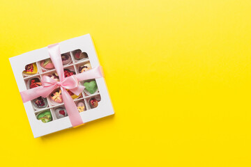 Box with sweet chocolate candies on color background, Various candy sweets. Valentines day gift box. Top view flat lay with copy space