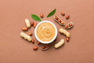 Bowl of peanut butter and peanuts on table background. top view with copy space. Creamy peanut...