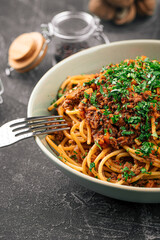 Eating appetizing spaghetti bolognese with herbs