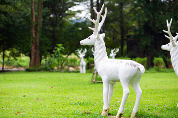 Naklejka na ściany i meble White deer statue in the forest