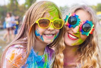 Happy mother with little daughter on holi color festival