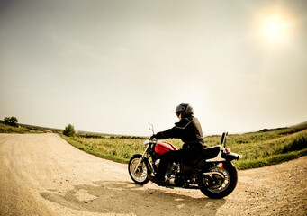 Fototapeta na wymiar Biker on the road against the sky