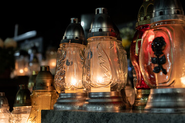 Cemetery grave candle glass lanterns, znicz illuminated at night. Memorial light remembrance...