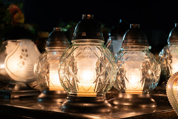 Cemetery grave candle glass lanterns, znicz illuminated at night. Memorial light remembrance...