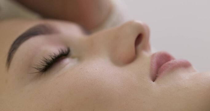 cosmetologist removes glue cotton strip under eye. Eyelash extension procedure