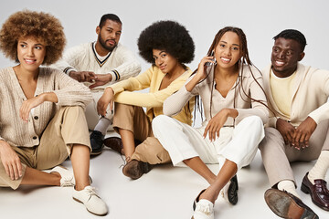 group of optimistic african american people in casual attire sitting on grey background, Juneteenth