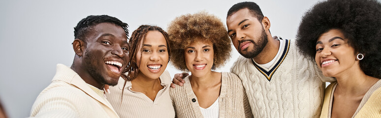 group of happy african american friends bonding and hugging on grey background, Juneteenth banner