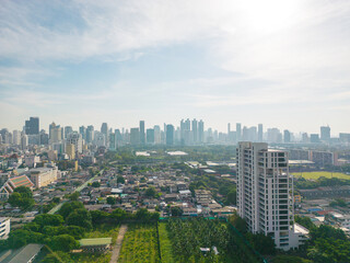 Fototapeta premium Aerial view of Lumphini Park backgrounded by the Silom area skyline office building business district