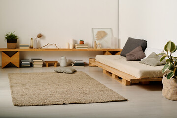 Beige carpet lying on the floor in the center of spacious bedroom with comfortable bed and wooden...