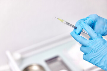 Physician hand in blue gloves with syringe for injection. copy space
