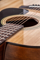 Fototapeta premium Classical guitar close up. Acoustic guitar on wood background.Music instrument concept