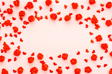 Decorative red flowers and hearts on a pink background, the concept of the holiday of all lovers Valentine's Day or wedding, top view, copy space