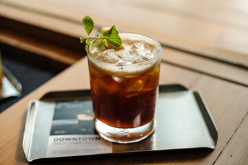 A glass of iced americano coffee (text “DOWNTOWN is coffee’s name)
