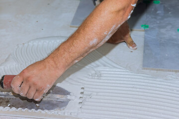 During installing ceramic tiles on concrete floor with adhesive mortar cement plaster