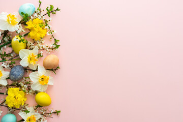 Naklejka na ściany i meble Festive background with spring flowers and Easter eggs, white daffodils and cherry blossom branches on a pink pastel background