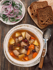 Clear soup with pork, potato, carrot and rosehip. Traditional russian siberian baikal soup yushka...