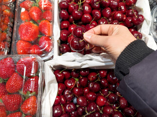 choosing cherries in a grocery store