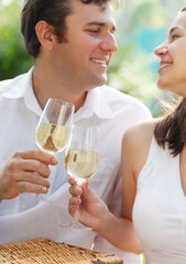 Young happy couple enjoying a glasses of white wine