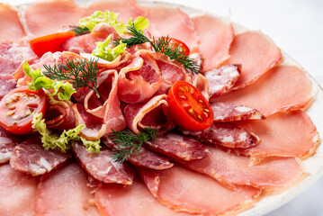 Salami, sausage and Parma ham sliced on plate