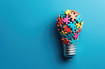 A light bulb made up of coloured puzzle pieces on a coloured background
