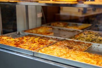 Authentic Italian pizza in a restaurant display window. Various pizzeria in glass window display....