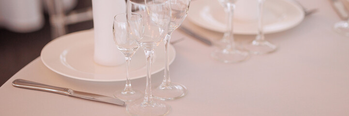 Three empty glasses for alcoholic beverages of vodka, wine and champagne are on the table. Banner...