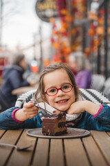 Un enfant mange un gâteau dans un café