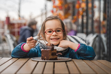 Un enfant mange un gâteau dans un café