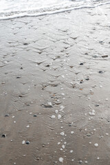 Fototapeta na wymiar Beach with stones pebbles in dark sand Dominical Costa Rica