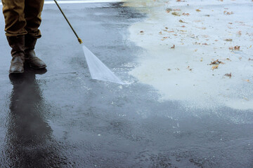 Street is sprayed clean using pressurized water, wet washing to clean it