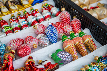 European Christmas market stall in  Old Town. colorful Christmas ornaments are some of the most popular souvenirs with tourists at seasonal fairs.