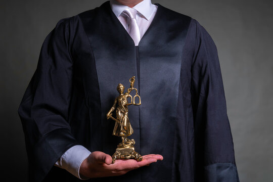 german lawyer with a robe holding a statue of Lady Justice