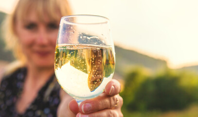 A woman drinks wine against the backdrop of mountains. Selective focus.