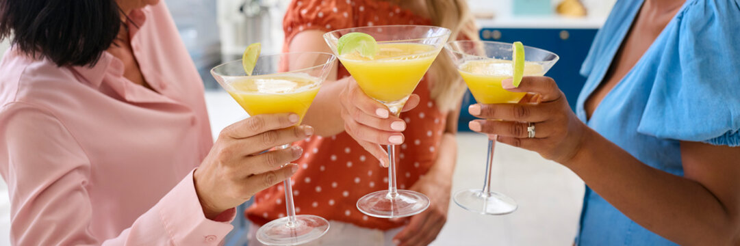 Close Up Of Three Mature Female Friends At Home Celebrating With Cocktails Together