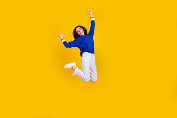 Fototapeta na wymiar Full body photo of ambitious successful woman raised fists up jumping trampoline celebrating victory isolated on yellow color background