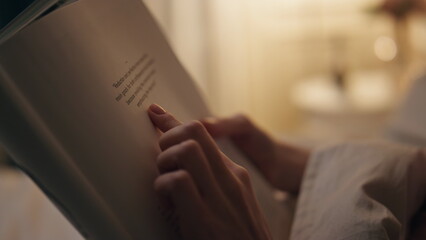 Closeup hands holding book indoors. Smiling peaceful woman reading favourite