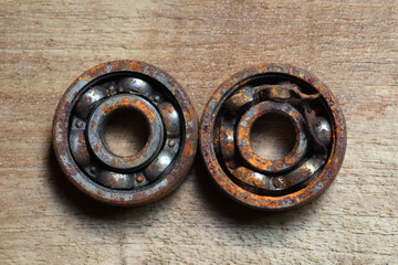 old rusty and damaged  ball bearing on wood  table .  corrosion of steel . rusty ball bearing