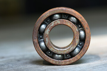 old and rusty ball bearing with grease stain  . rusty bull bearing on wood table . close up  ....