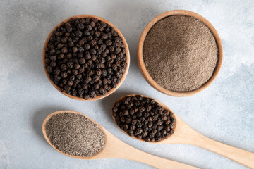  Ground black pepper with grains of black pepper on bright background 
