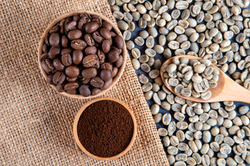 Ground coffee with roasted coffee beans on burlap sack,top view 
