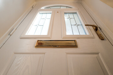 Unusual, vertical aspect of a newly installed double glazed and secure PVC door. Showing part of...