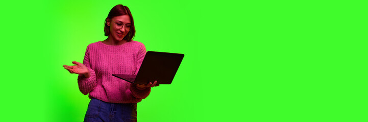 Beautiful young concentrated, positive business woman wearing knitted sweater using laptop while...